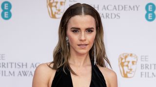 Emma Watson is pictured with cool, brunette hair whilst attending the EE British Academy Film Awards 2022 at Royal Albert Hall on March 13, 2022 in London, England.
