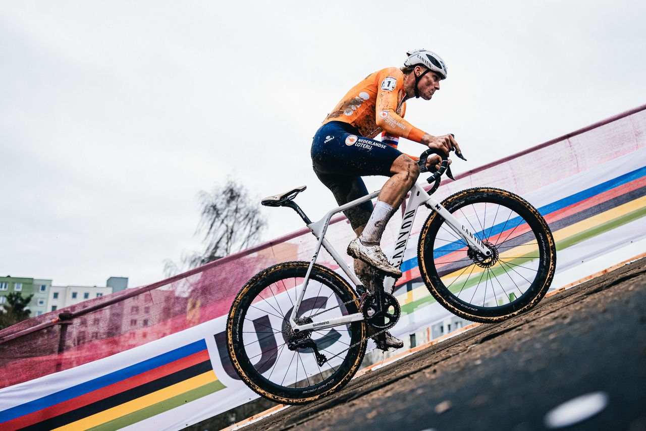 Mathieu van der Poel climbs at the 2024 cyclocross World Championships, in his orange Dutch kit, on a white Canyon