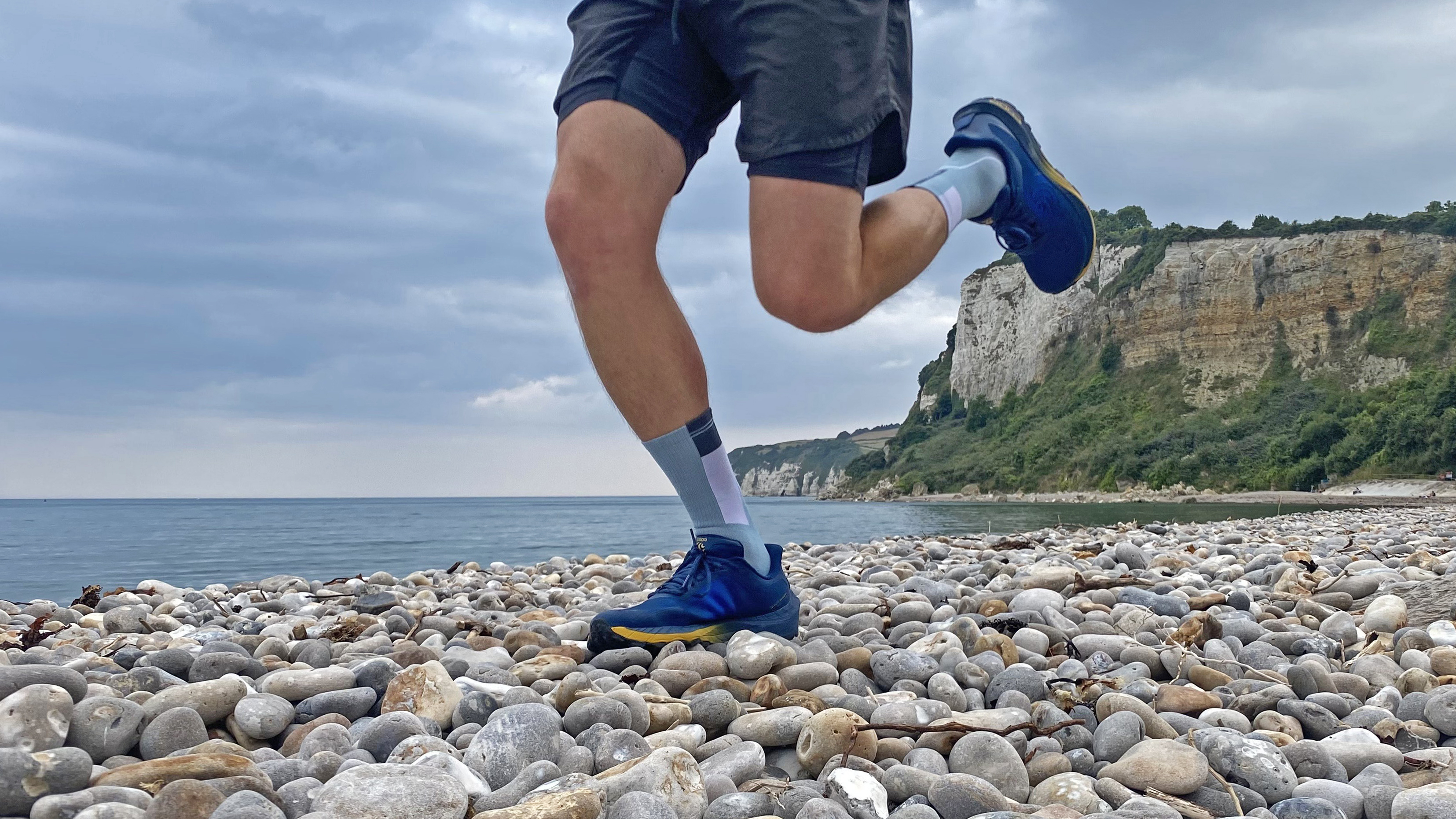 Runner on a pebble beach wearing the Buff CoolNet Crew Running Socks