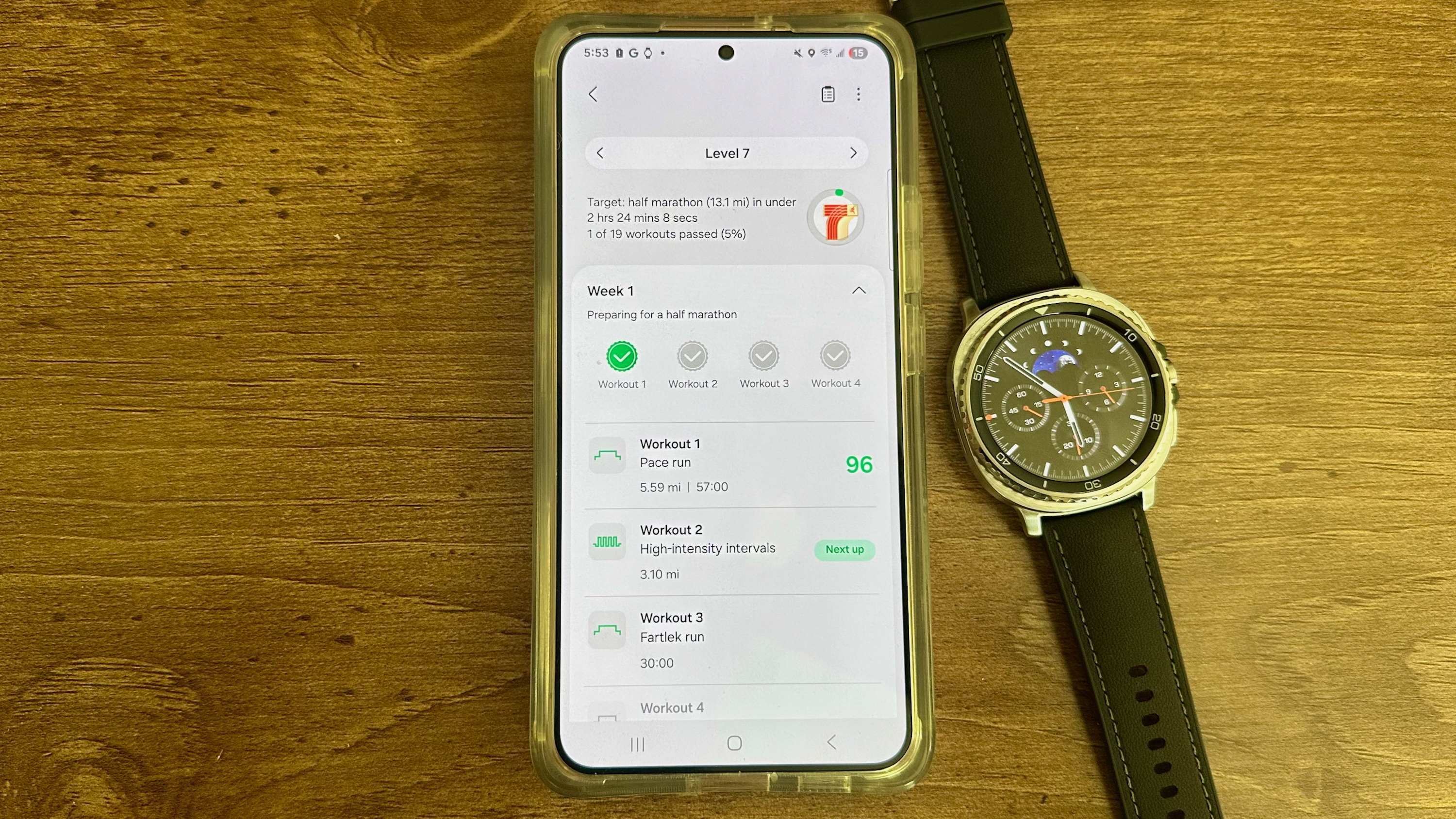 A Galaxy phone showing a Level 7 Samsung Running Coach training plan, with Week 1 showing one workout completed with a 96/100 score and three upcoming workouts. Next to the phone is a Galaxy Watch 8 Classic.