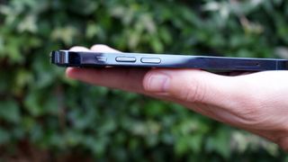 An iPhone 12 Pro in someone's hand, viewed from the side