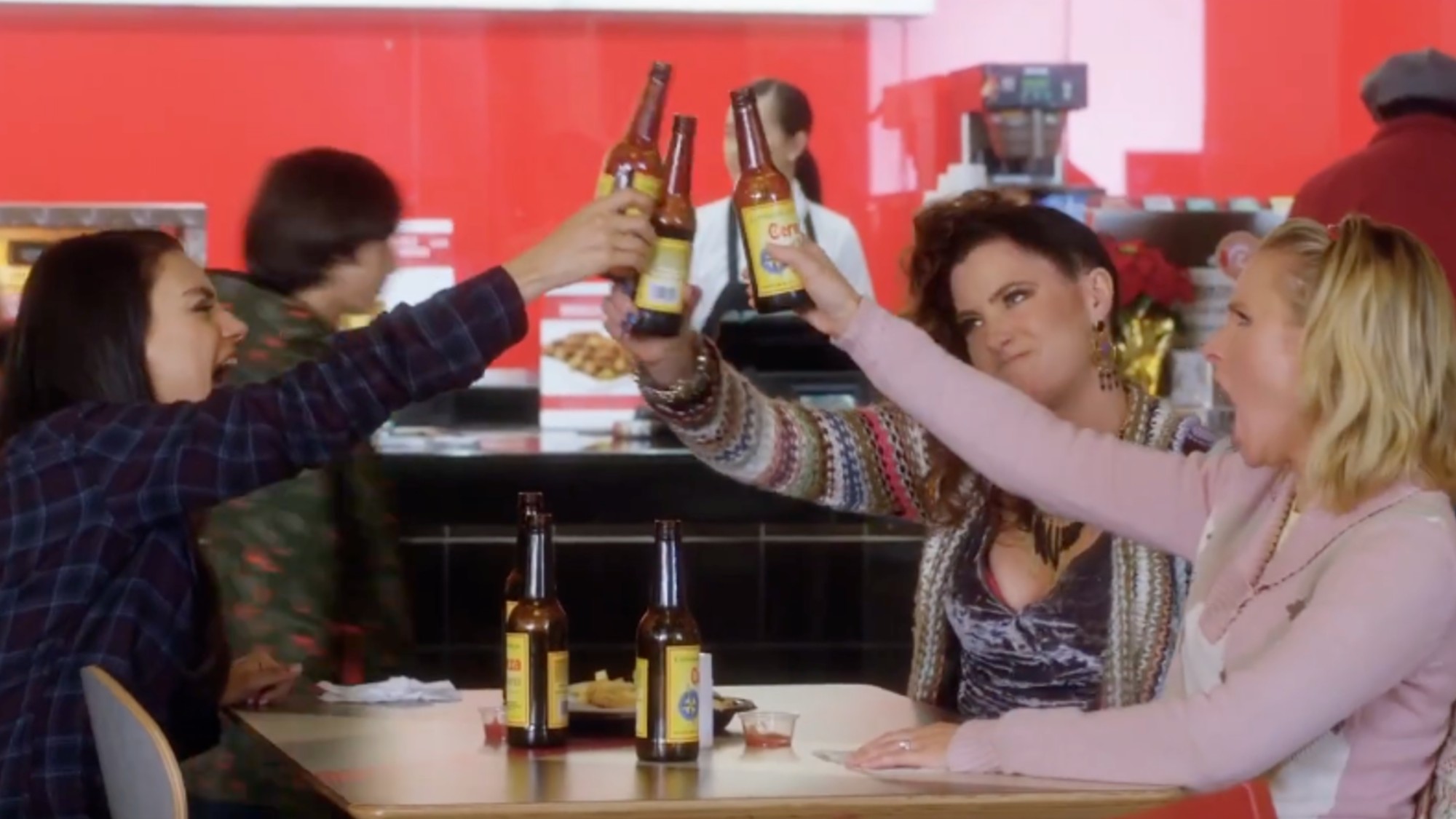 Three women holding up beer bottles and cheersing in Bad Moms Christmas