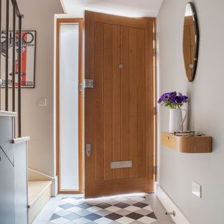 hallway with wooden door and chequered flooring