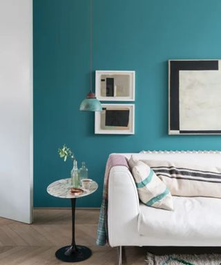 living room with neutral sofa, teal wall, parquet floors, gallery wall