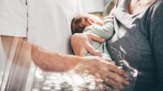 A stock photo of parents holding their baby. 