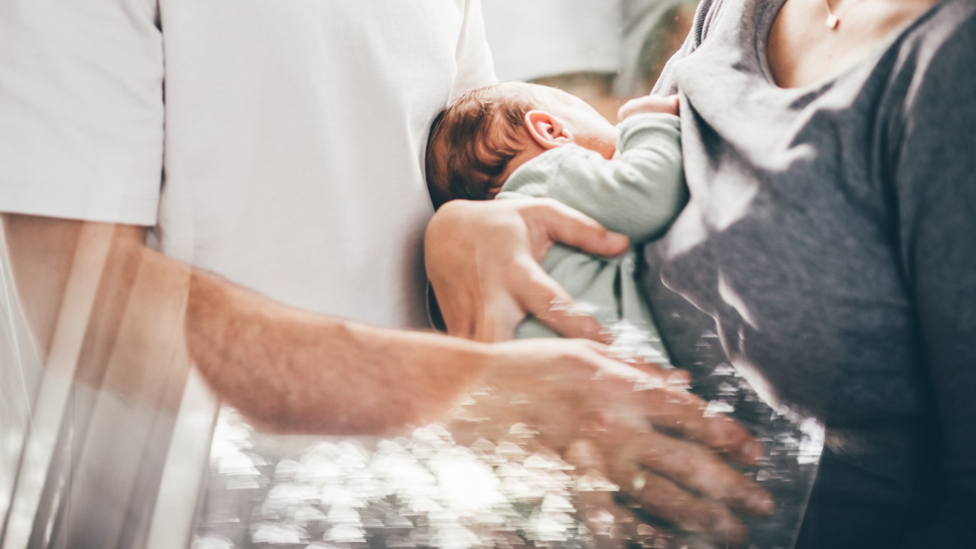A stock photo of parents holding their baby. 