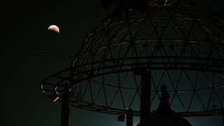 A photo of the 'blood moon' above the Little Prince monument in San Salvador, El Salvador.