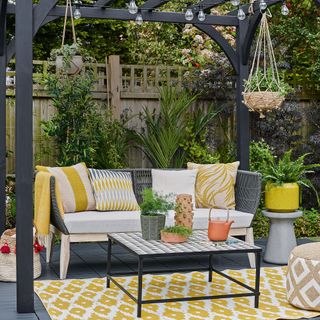 decking area with plant in pots and sofaset with cushions