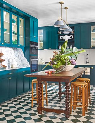 Small kitchen with teal painted cabinets and check floor