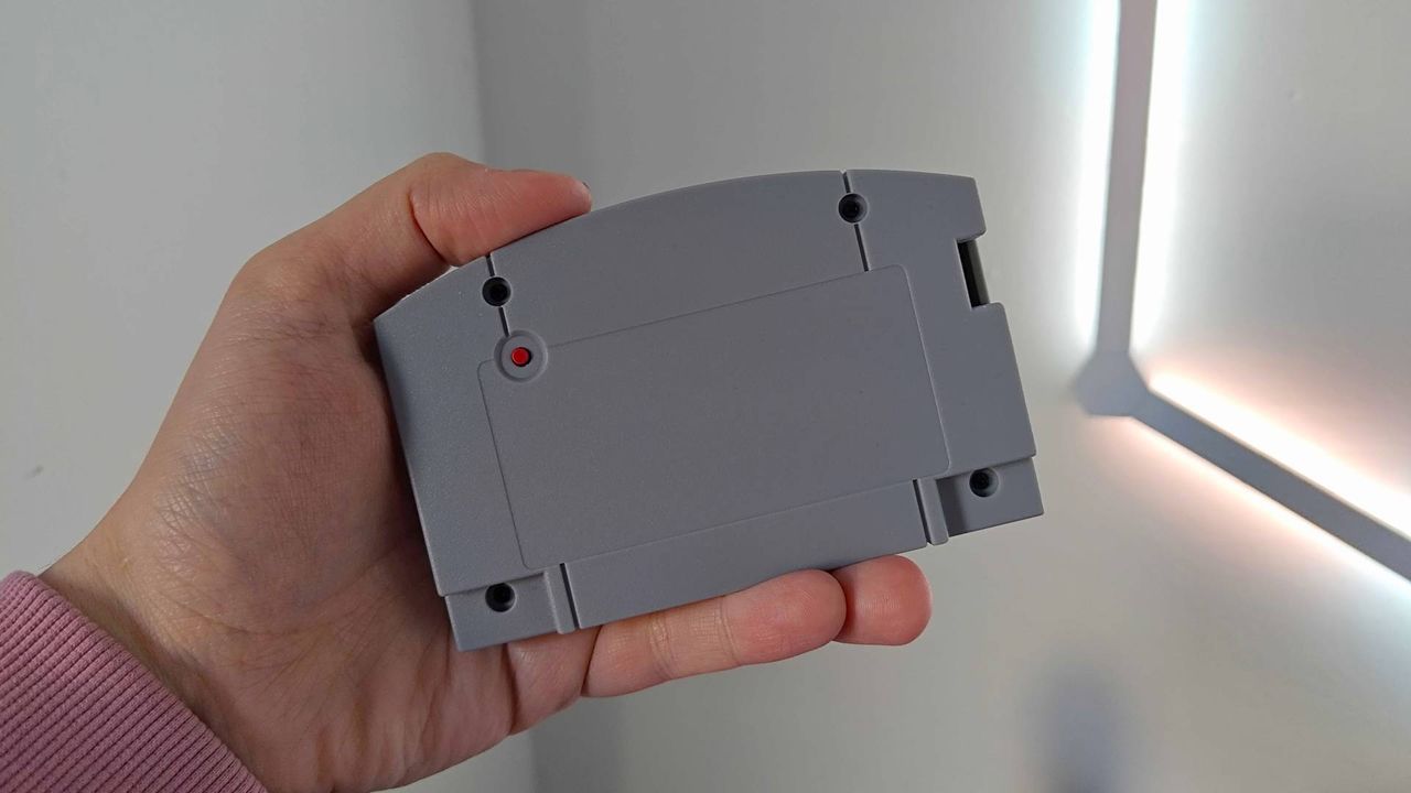 Hand holding Summercart64 with back of cartridge facing foward
