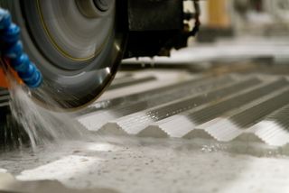 A close-up of Quartz being cut at Compac using a circular saw.