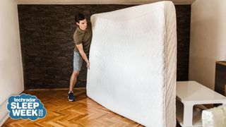 A man moves an old mattress out of a bedroom, ready for it to be donated to charity