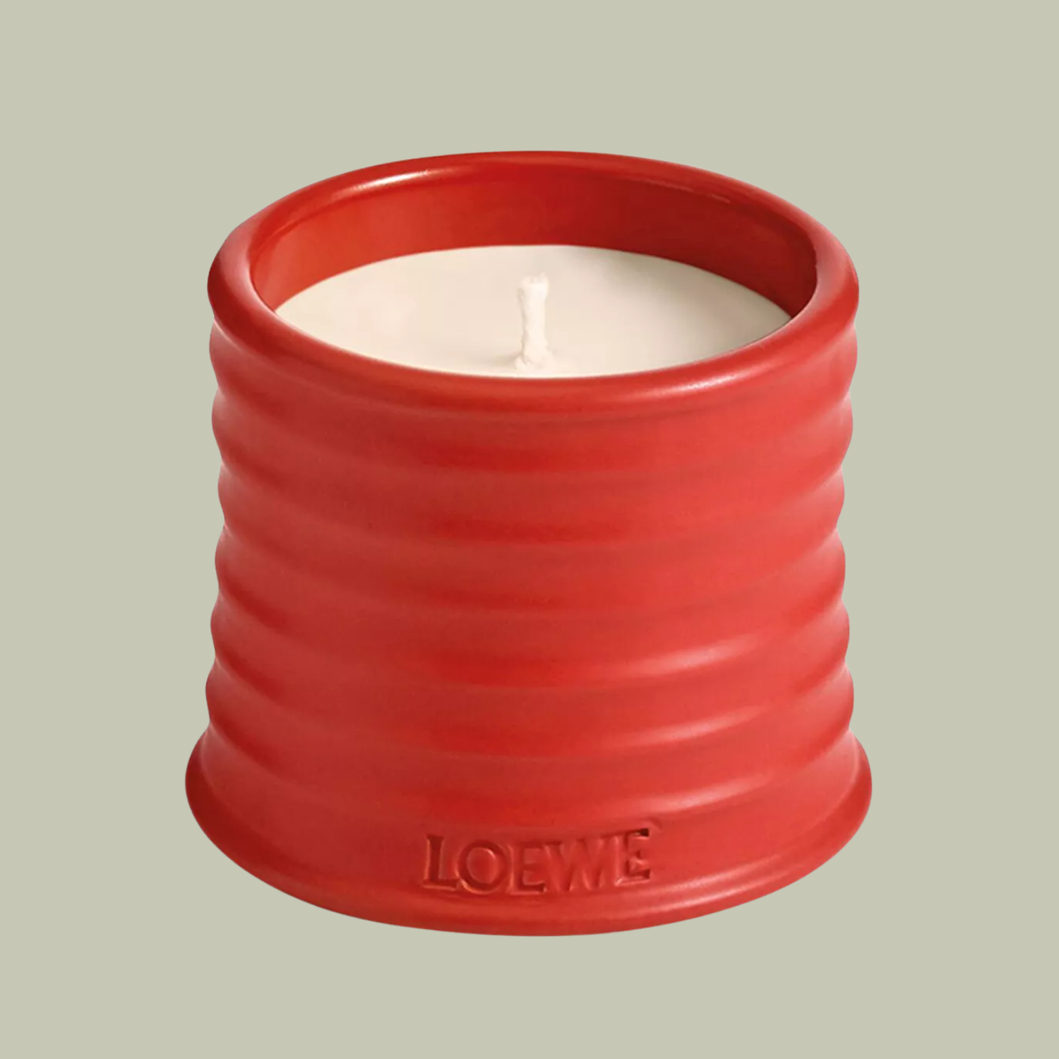 A candle in a ribbed orange vessel