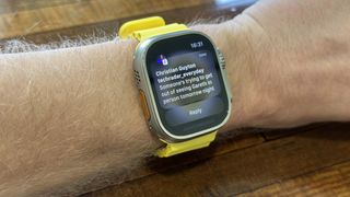 Apple Watch Ultra med en gul rem rundt et håndledd.