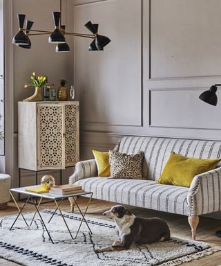 neutral living room with striped sofa and yellow accessories