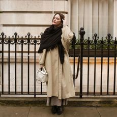 @annacascarina wearing a trench coat and scarf