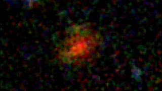 a blurry, pixelated red and green splotch dissipates outward to black.