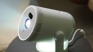 White portable projector beaming light