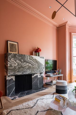 Pink living room with grey marble fireplace