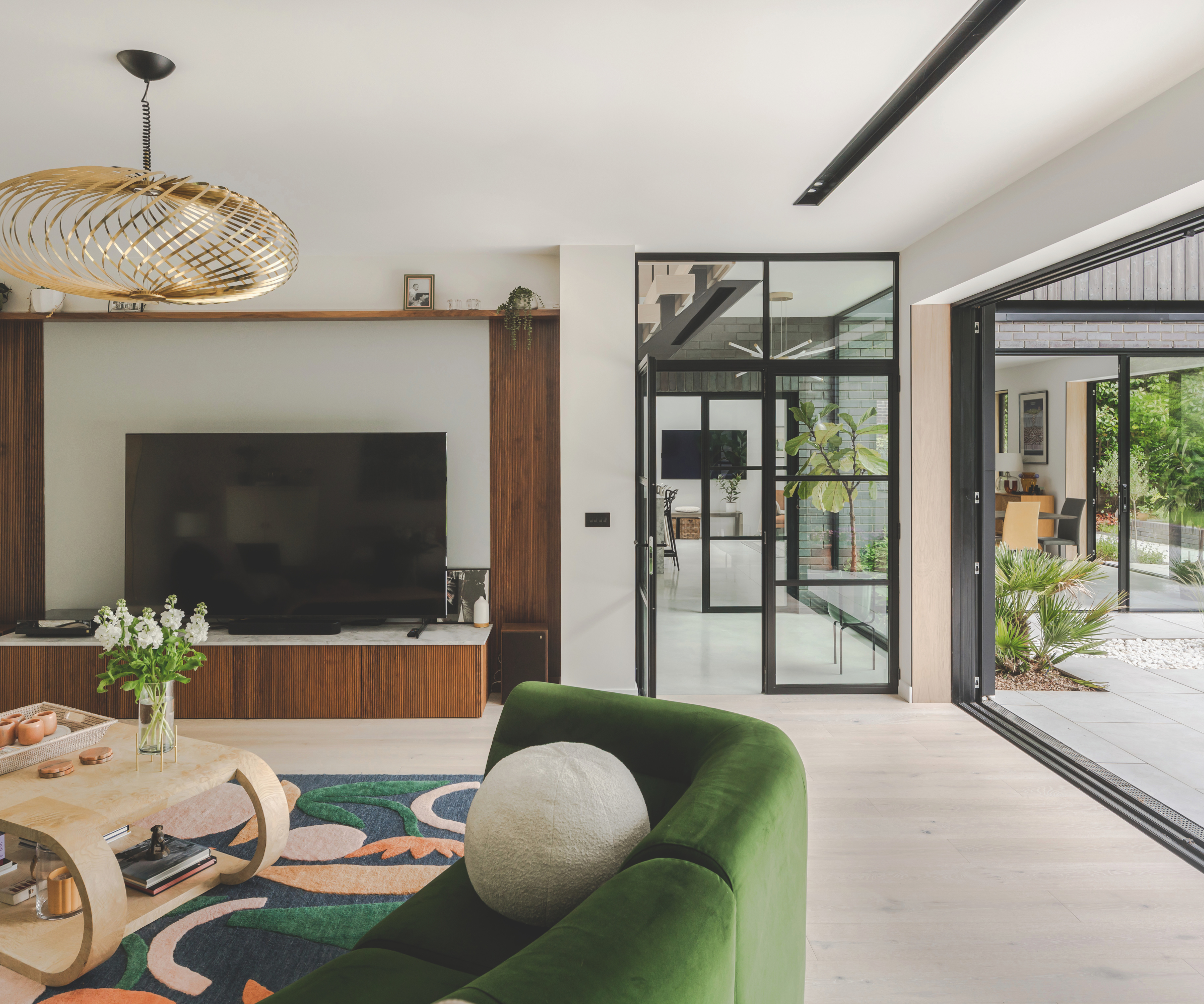 Living room with patio doors on right hand side and black framed door straight ahead