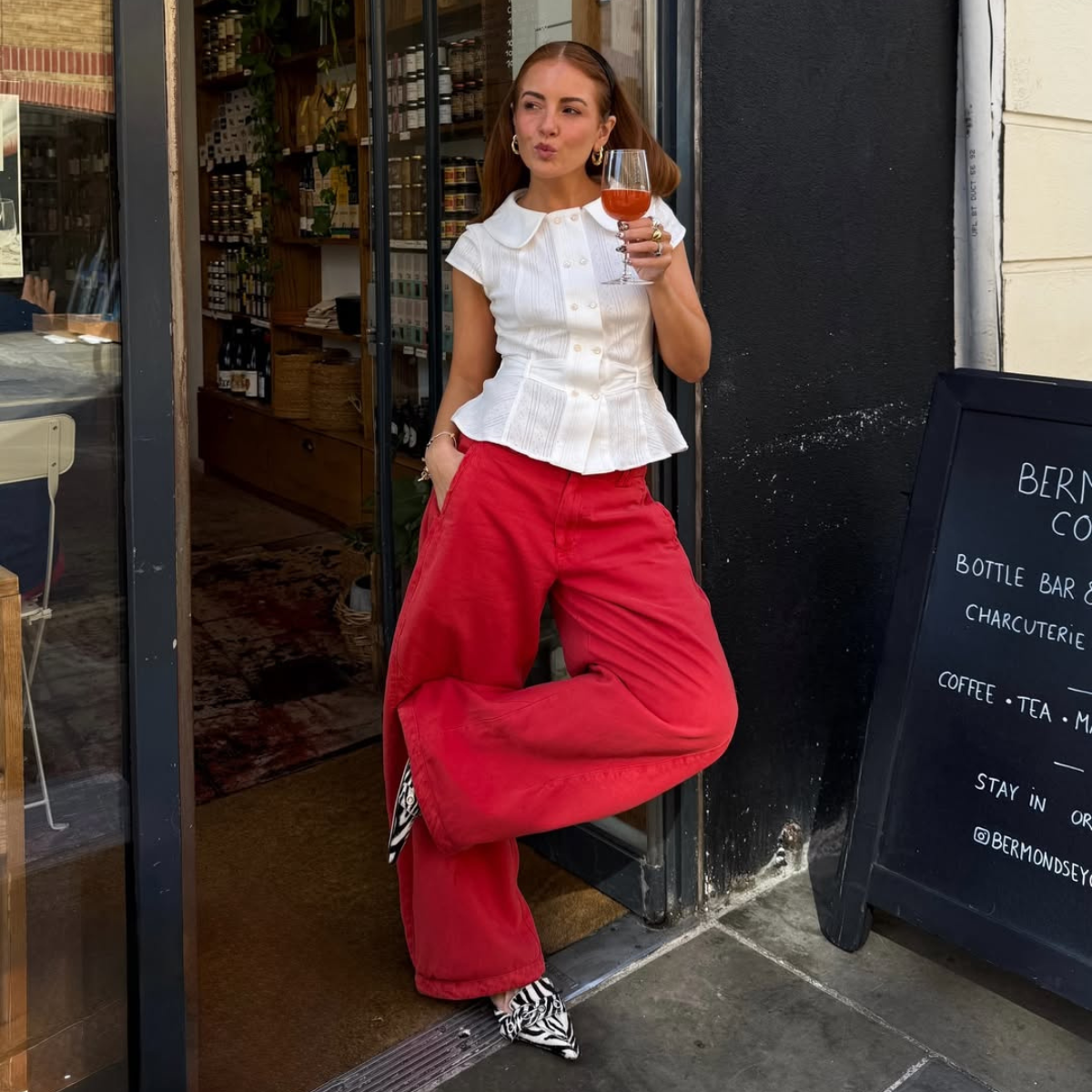 Influencer Rebecca Ferraz Wyatt wearing wide leg jeans and a fitted shirt. 