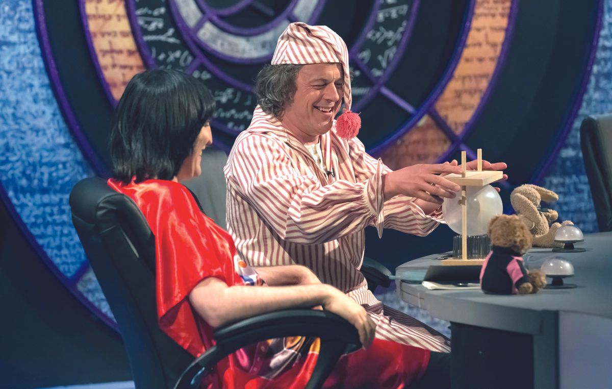 Sandi Toksvig, Alan Davies, Holly Walsh, David Mitchell and Noel Fielding are in pajamas and slippers and, in Alan’s case, a nightcap.