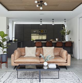 Living area with tan sofa and white and black geometric rug