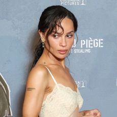 Zoe Kravitz wearing a Saint Laurent lace-trimmed slip dress on the Caught Stealing red carpet