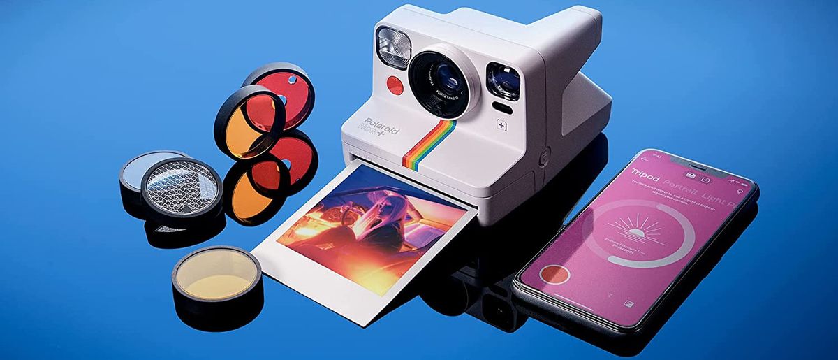 Polaroid Now+ review image on blue background with accessories and smartphone app