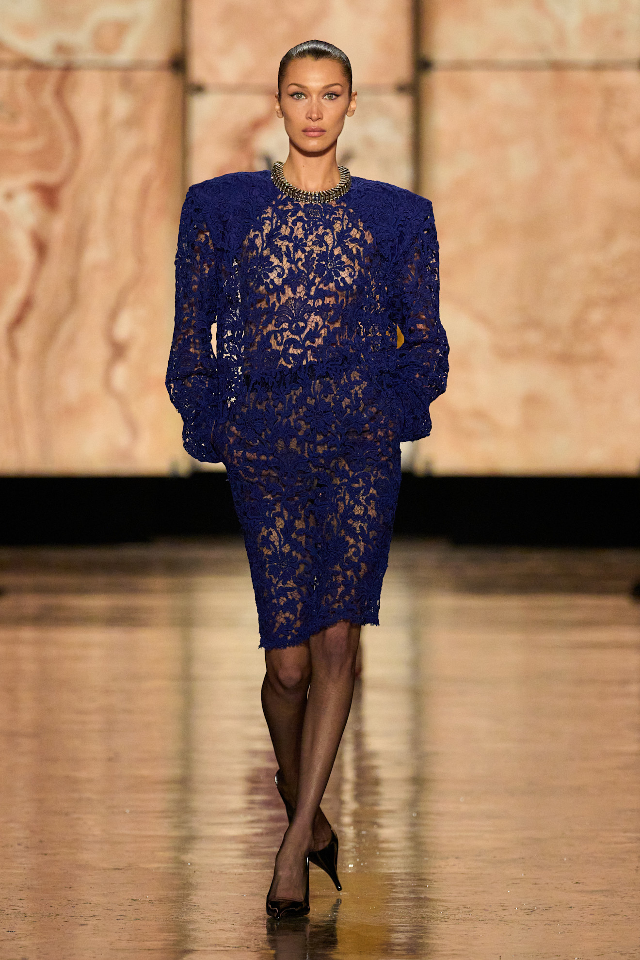 Bella Hadid walked the Saint Laurent Fall 2025 runway in a sheer lace shoulder-padded dress