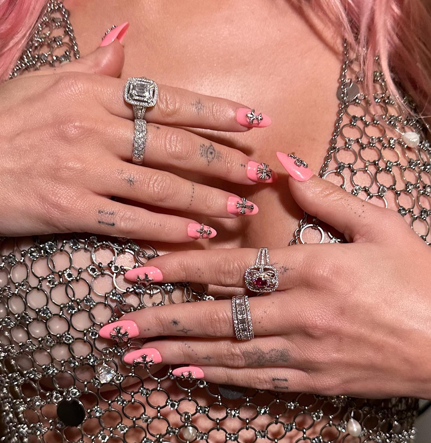A manicure with a hot pink base and silver crosses by Brittney Boyce