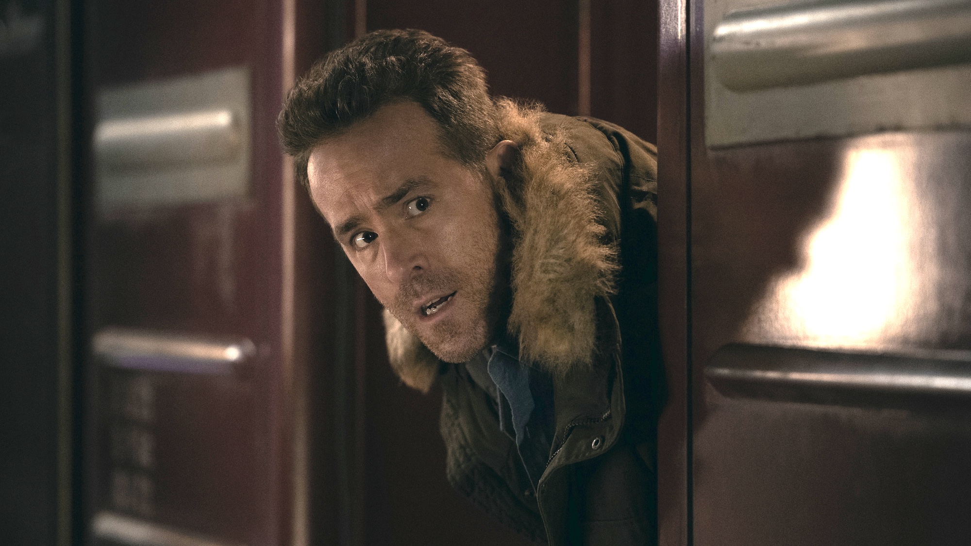 Ryan Reynolds poking his head out in fur jacket in Mayday