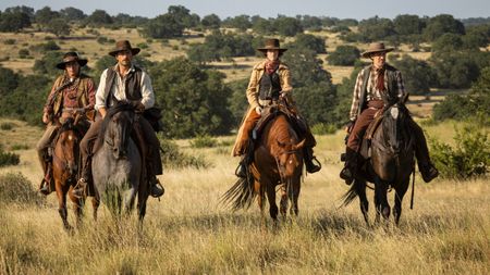From left to right: Doug Hall as Two Spears, Brandon Sklenar as Spencer Dutton, Jennifer Carpenter as Marshall Mamie Fossett and Steve Luna as Deputy Clint Peterson riding horses in 1923. 