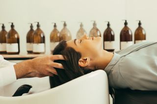 Ricardo Vila Nova massaging a client's scalp during a treatment.