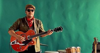 Mauro Lopez of the Animeros wears shades and poses with an orange Gretsch.