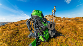 Backpack and walking poles on a hilltop