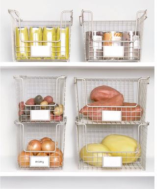 Pantry shelves with deep white metal wire baskets containing cans and jars and vegetables