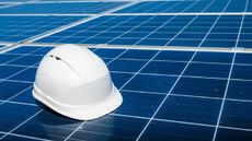 A close-up of a white helmet on a row of solar panels