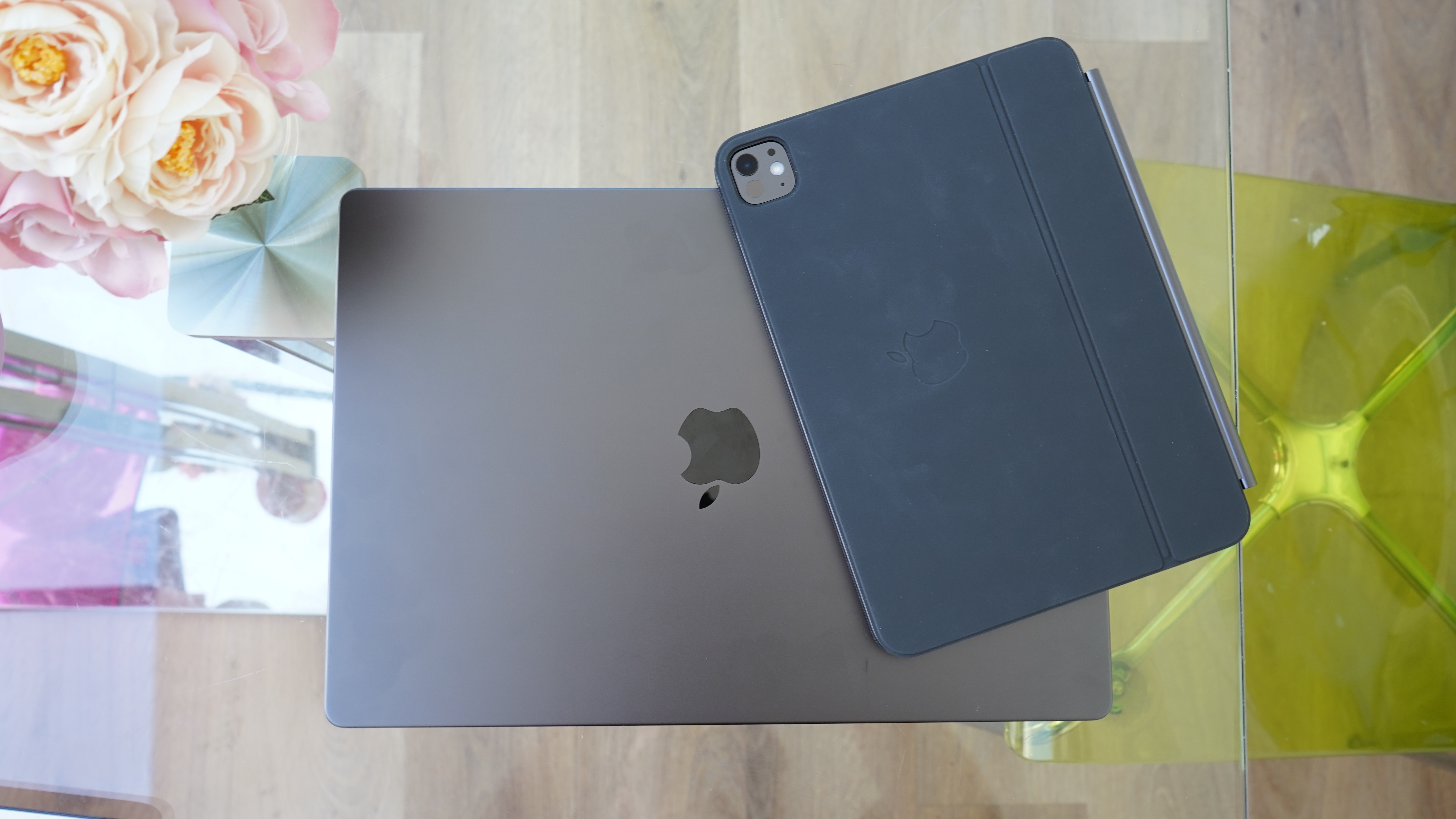 Closed MacBook Pro and iPad Pro on glass table