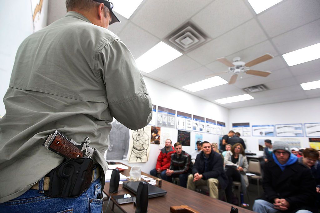 A man with a gun in a holster on his hip.