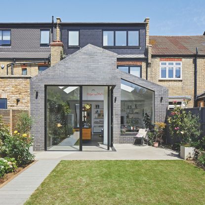 Exterior of a kitchen extension, with sliding doors to the garden, and a large picture window