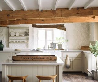 A traditional kitchen with mushroom colored cabinets and a white and gray marble-look countertop