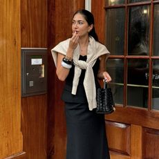 Photo of a woman applying lipstick outside