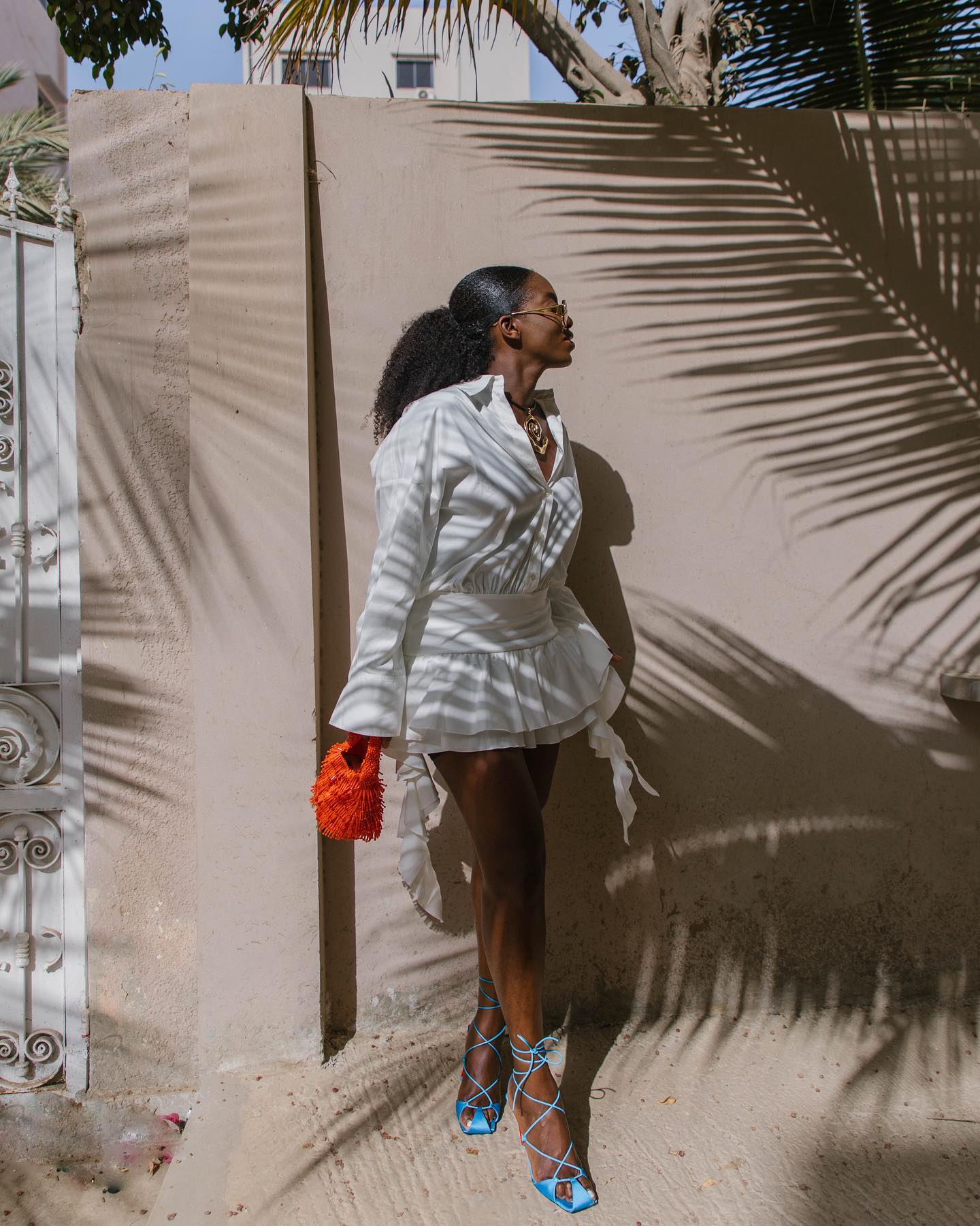 Photo of a woman wearing a textured ponytail and white dress at the beach