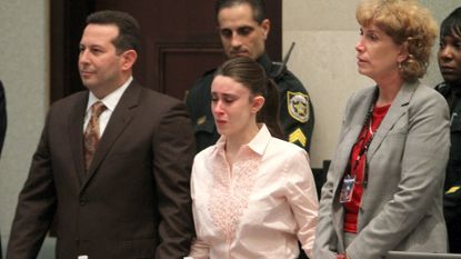 Casey Anthony reacts to being found not guilty on murder charges at the Orange County Courthouse in Orlando, Florida, Tuesday, July 5, 2011. At left is her attorney Jose Baez. On the right is attorney Dorothy Clay Sims.