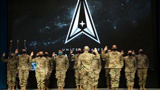 military personnel in uniform raise their right hands to take the oath of office officially transferring from the United State Air Force to the United States Space Force