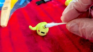 Cleaning a sports earbud with a cotton swap