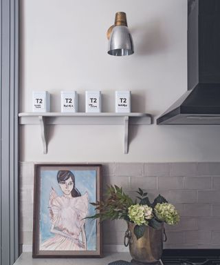 Grey fitted kitchen, worktop, portrait painting, shelf, wall light