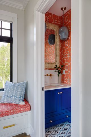 powder room with blue vanity and orange wallpaper