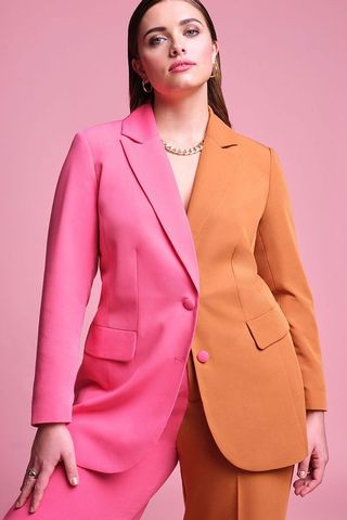 model wearing blazer that's bright pink on one side and tan on the other